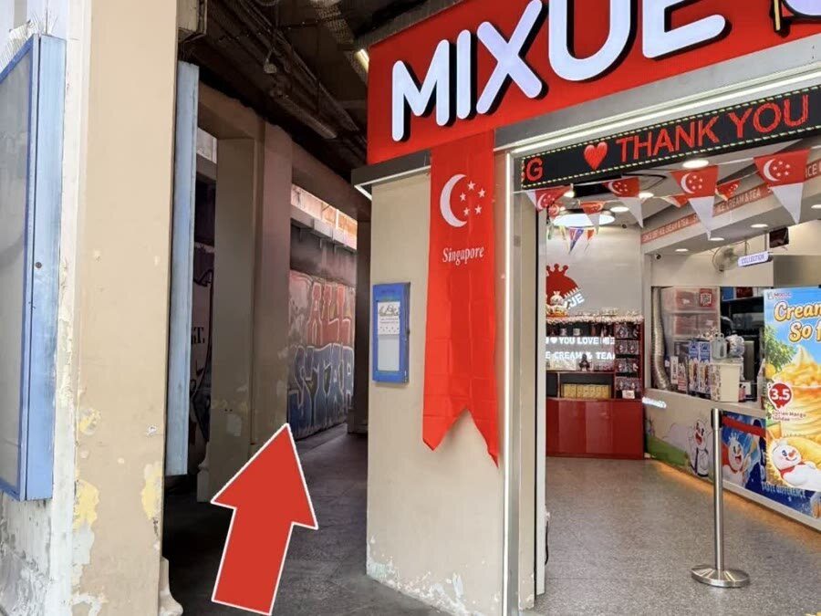This way arrow pointing into the walkway beside Mixue toward the cat cafe entrance